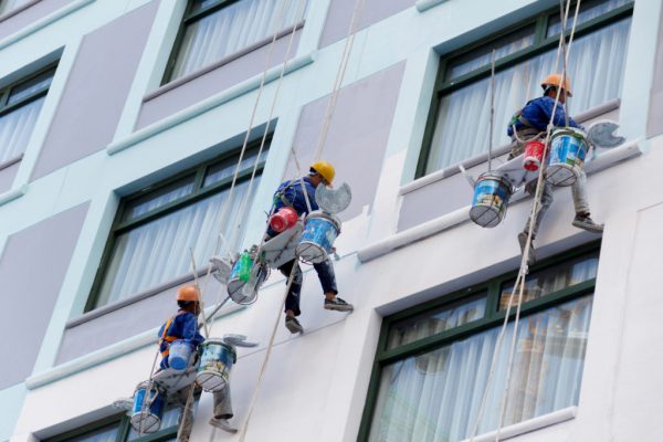 Worker are painting the color in high rise buildings. Worker are painting the color in high rise buildings.